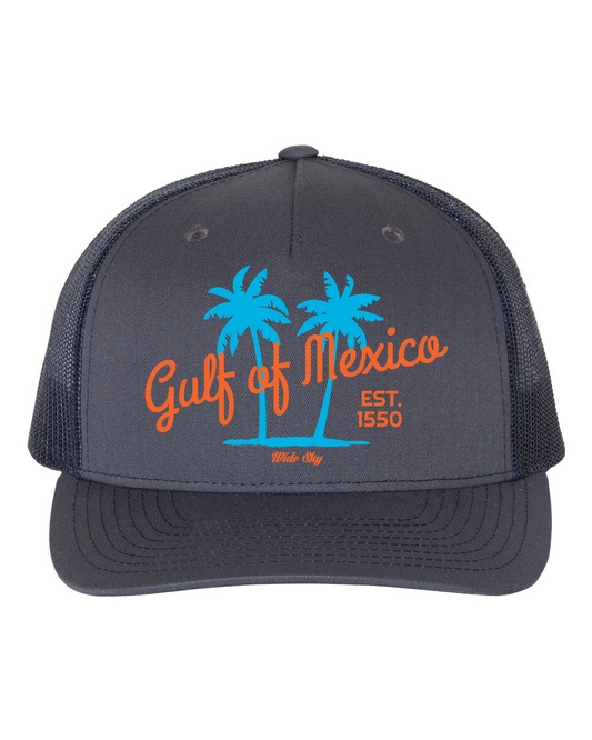 Ombre blue to navy trucker snapback hat featuring "Gulf of Mexico" heat press transfer logo in white, blue and orange lettering, displayed showing mesh back panel and adjustable snap closure