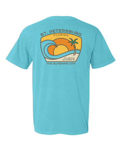 Lagoon colored garment-dyed t-shirt featuring a tropical wave and palm tree design with the latitude and longitude coordinates of St. Petersburg, Florida printed on front and back